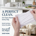 Person holding white dry wipes with text about Pure & Dry dry wipes in a kitchen setting.
