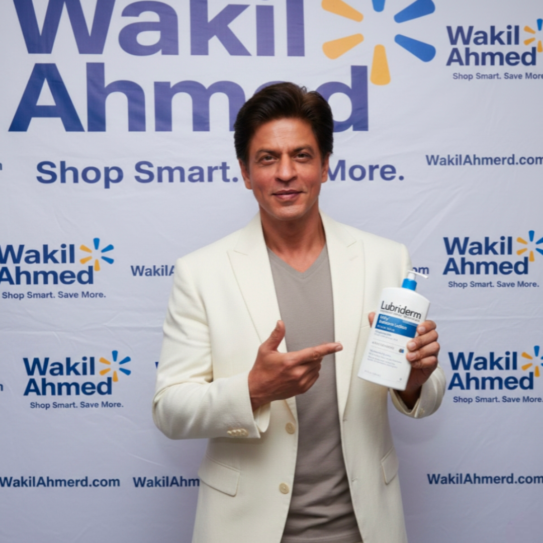 بِسْمِ ٱللَّٰهِ ٱلرَّحْمَٰنِ ٱلرَّحِيمِ
إِنَّا فَتَحْنَا لَكَ فَتْحًا مُّبِينًا.
Shahrukh Khan holding a bottle of Lubriderm in front of a Wakil Ahmed backdrop
