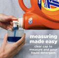 Measuring cap pouring Tide Original HE liquid detergent into a measuring cup